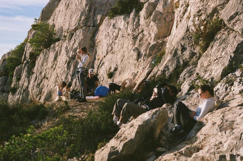 A few people lounge in the rocks and shrubs.