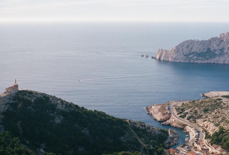 A church on a hill with a bay in the background.