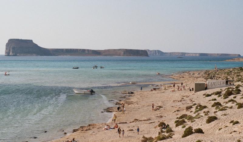 A stretch of beach with boats in the water.