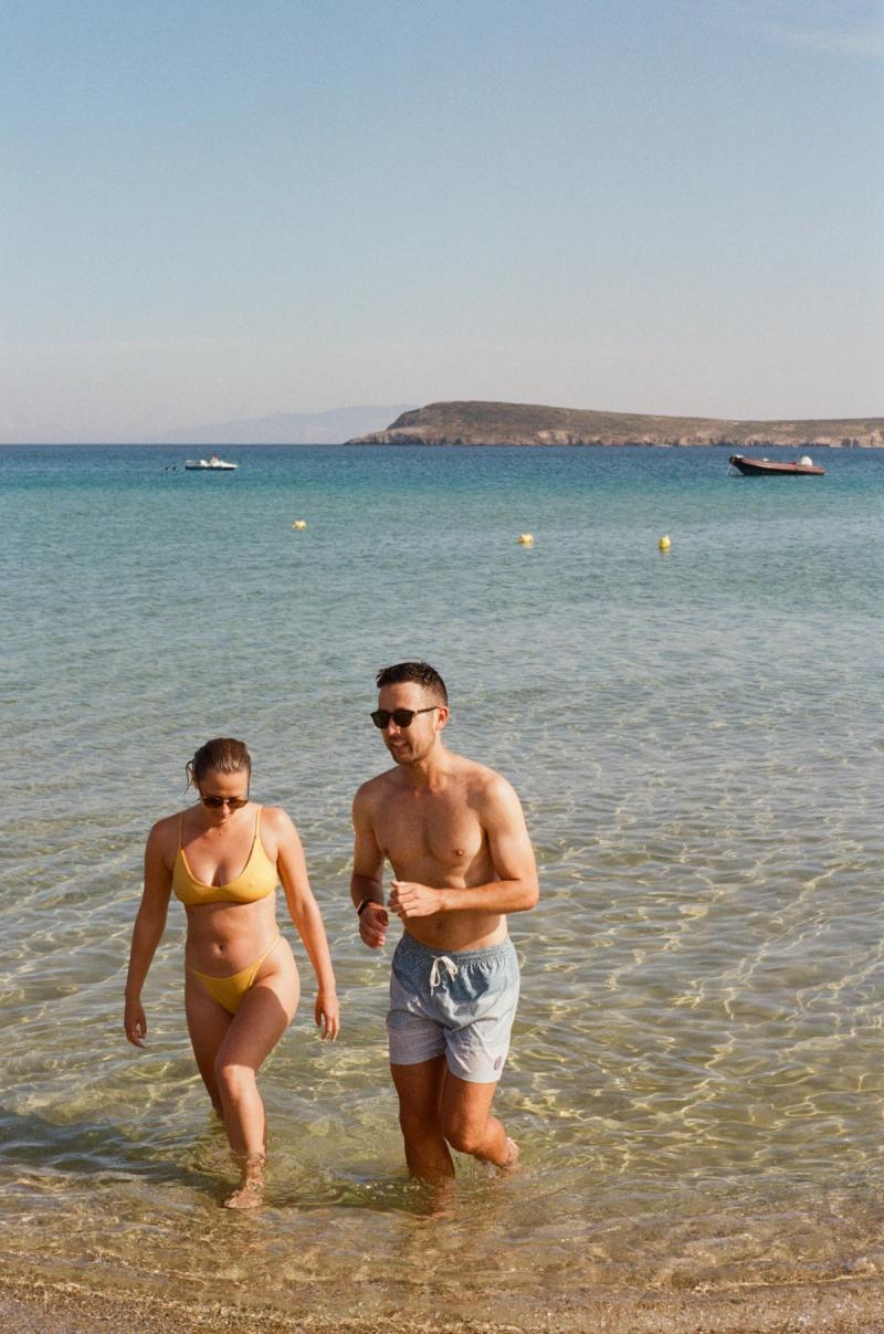 A couple chat as they walk back in from the ocean.