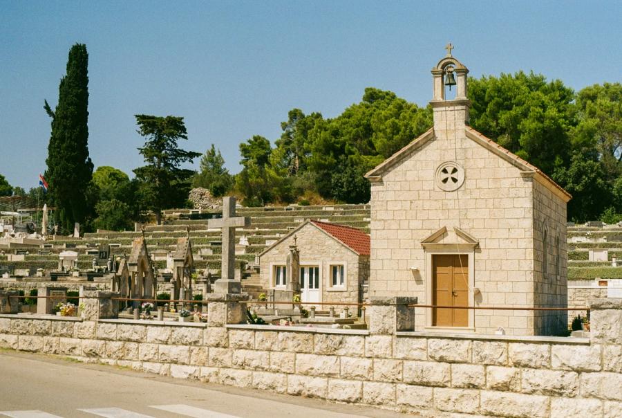 A church stands, backed by a graveyard.
